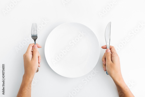 Whte plate with silver fork and knife on white background