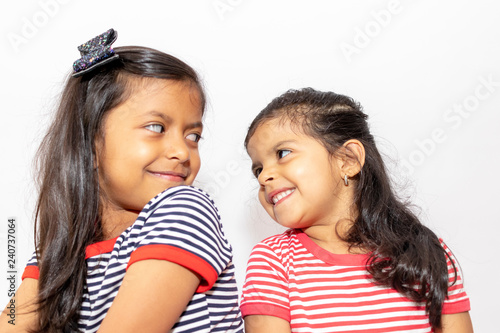 Cute sisters with striped dresses laughing