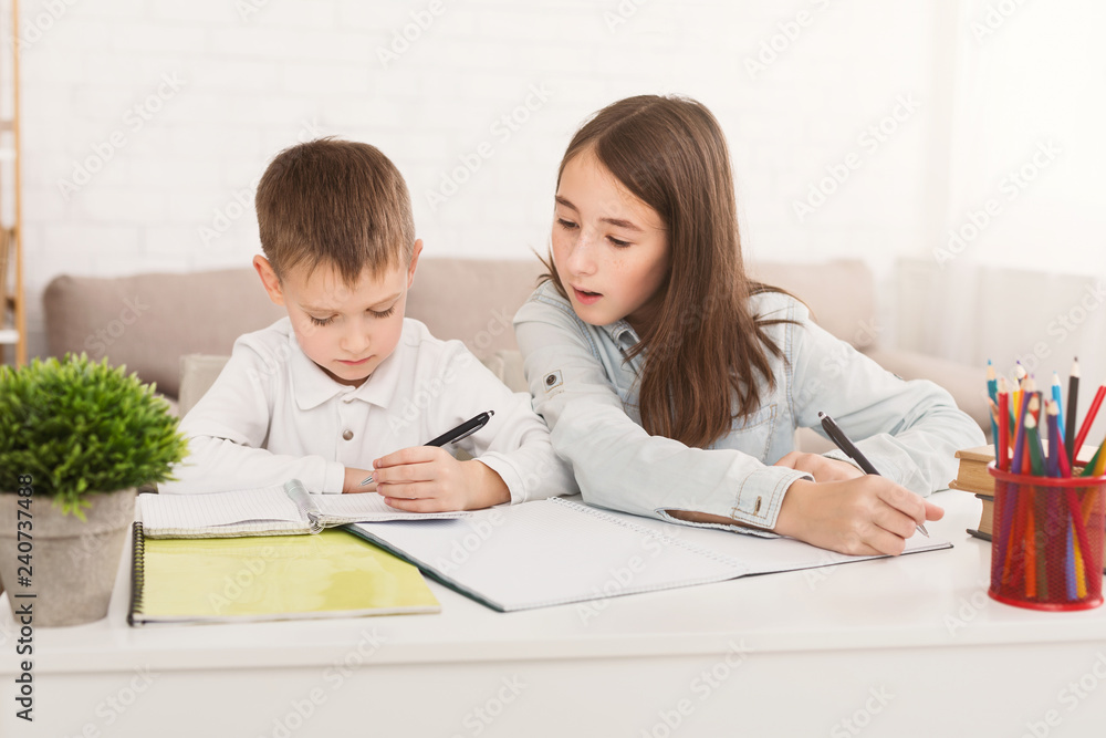 Learning at home. Sister helping brother doing homework Learning at home. Sister helping brother doing homework