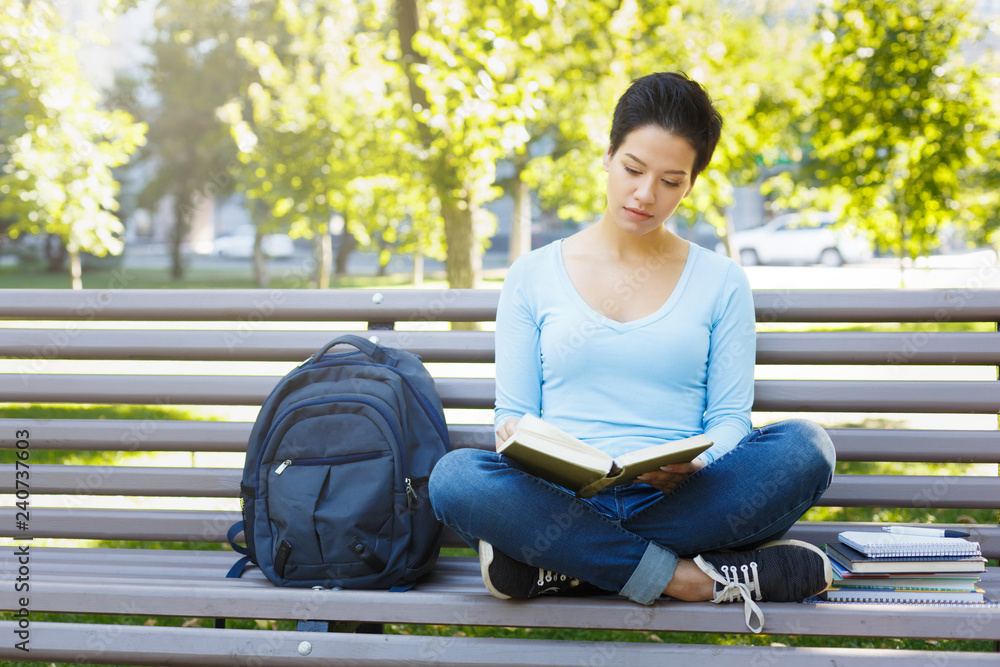 Obraz premium Shorthaired girl writing in notebook outdoors