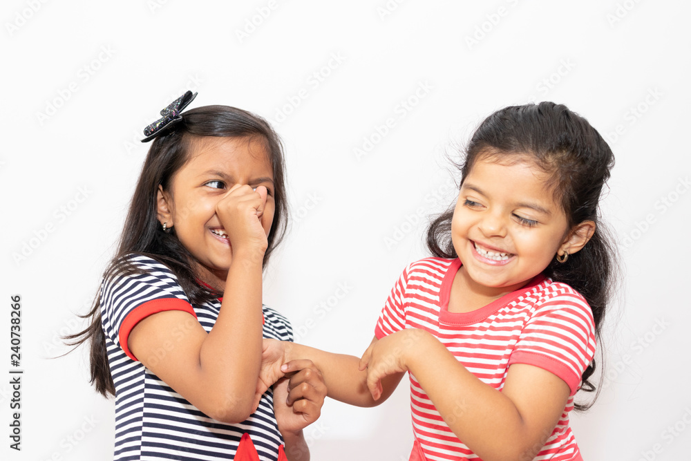 Cute sisters with striped dresses laughing Cute sisters with striped dresses laughing