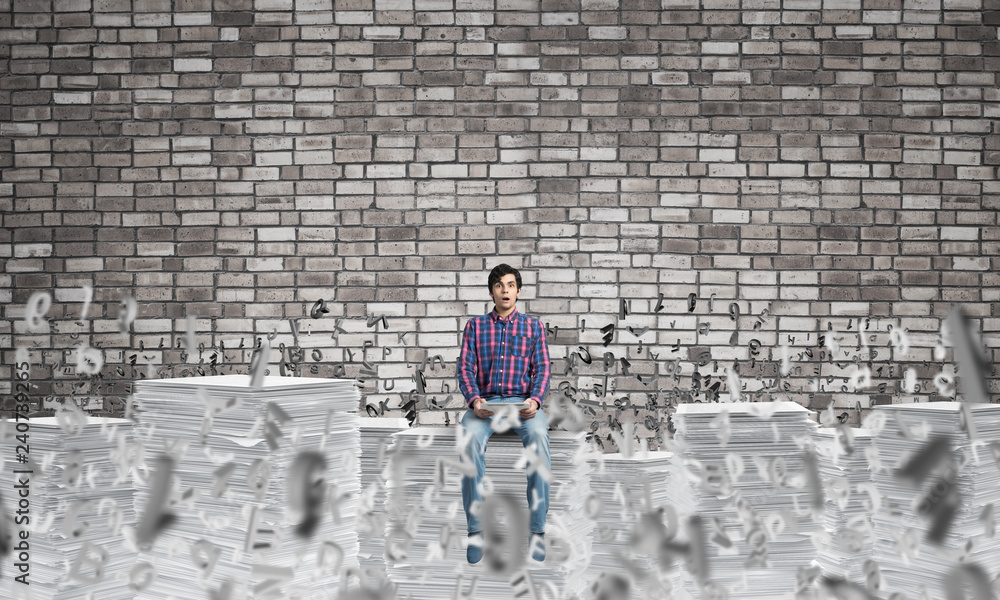 Attractive man sitting on pile of paper documents. Attractive man sitting on pile of paper documents.
