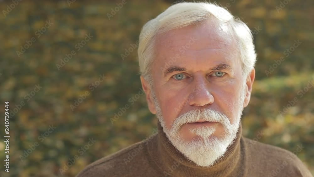 Tranquil, pensive grandfather staring into camera calmly, refreshment outdoors Tranquil, pensive grandfather staring into camera calmly, refreshment outdoors