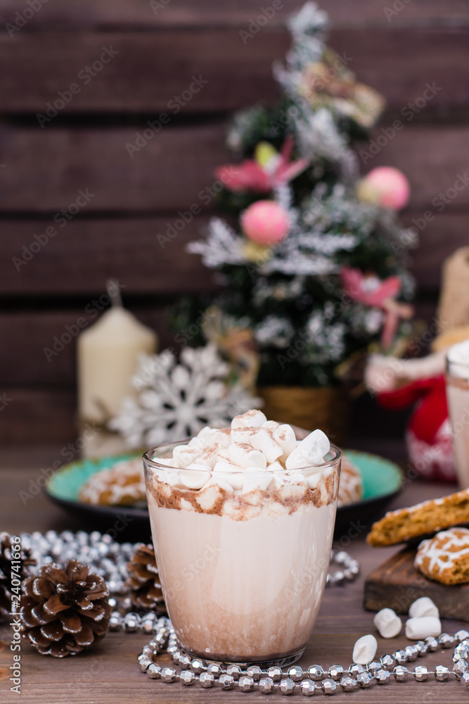 Hot cocoa with marshmallows in glasses on a wooden table in Christmas decorations Hot cocoa with marshmallows in glasses on a wooden table in Christmas decorations