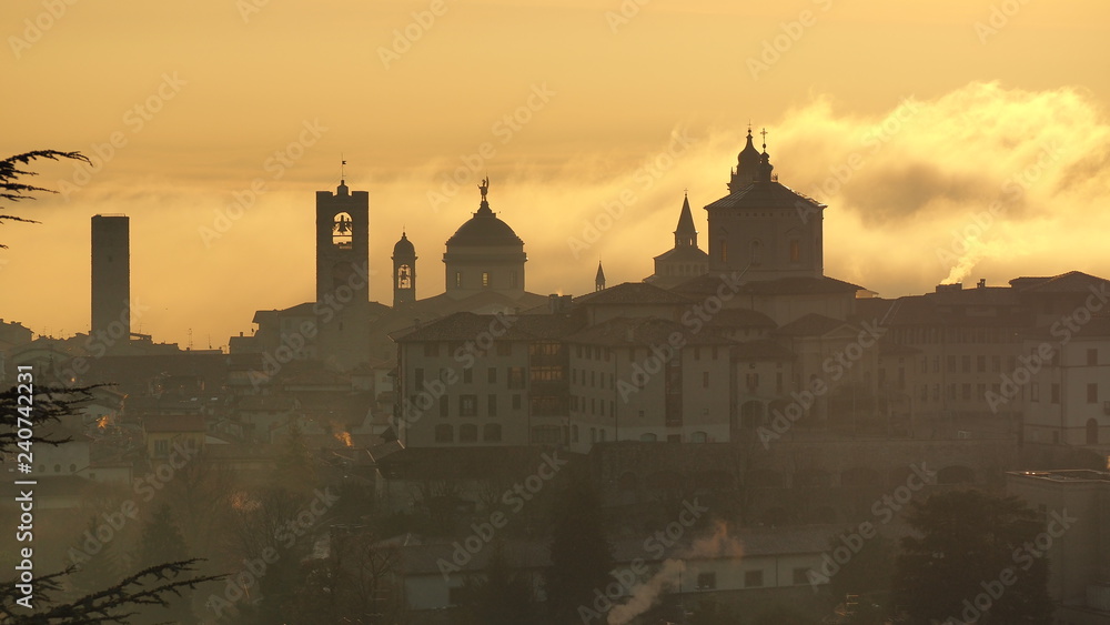 Bergamo, one of the most beautiful city in Italy. Amazing landscape of the old town and the fog covers the plain at sunrise Bergamo, one of the most beautiful city in Italy. Amazing landscape of the old town and the fog covers the plain at sunrise