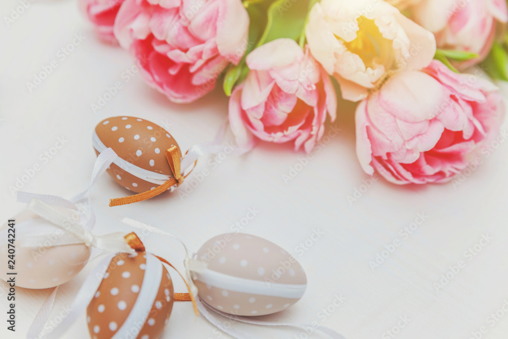 Spring greeting card. Easter eggs with moss cotton and pink fresh tulip flowers bouquet on rustic white wooden background. Easter concept. Flat lay top view copy space. Spring flowers tulips Spring greeting card. Easter eggs with moss cotton and pink fresh tulip flowers bouquet on rustic white wooden background. Easter concept. Flat lay top view copy space. Spring flowers tulips