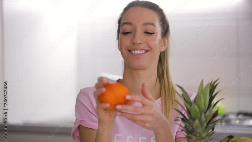 Portrait of happy woman eating fresh mandarin with enjoyment Portrait of happy woman eating fresh mandarin with enjoyment