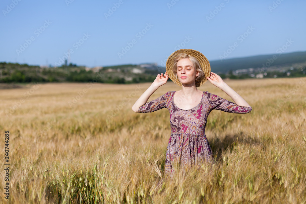 fashionable woman farmer in field of wheat harvesting rye