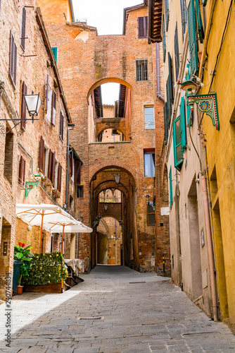 Fototapeta Naklejka Na Ścianę i Meble -  View of the beautiful street archway in the hill top town Siena