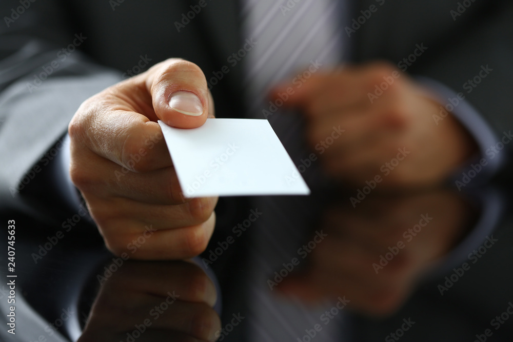 Male arm in suit give blank calling card to visitor closeup Male arm in suit give blank calling card to visitor closeup
