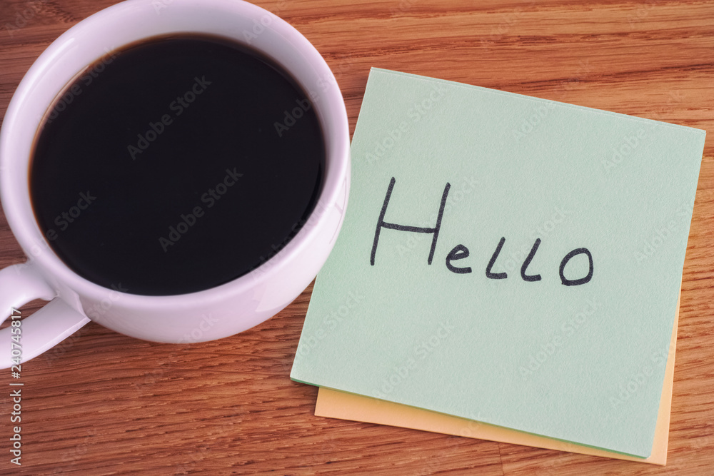 Post it note with writing Hello and cup of coffee Post it note with writing Hello and cup of coffee