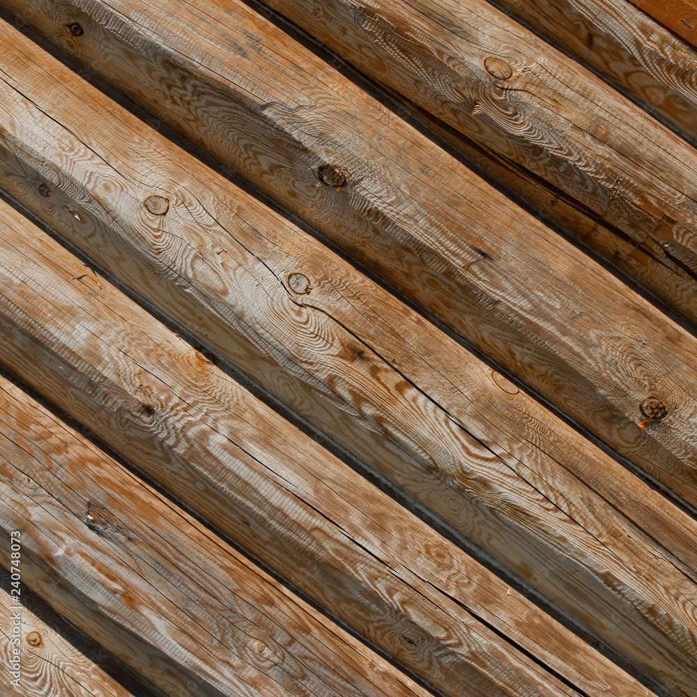 The logs are obliquely. Wooden rough traditional Wall of logs. The logs are obliquely. Wooden rough traditional Wall of logs.
