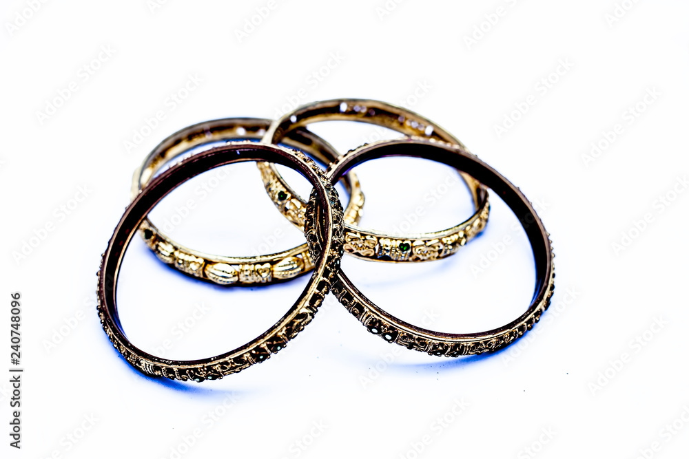 Close up of golden colored metal bangles isolated on white with some diamonds on it. Close up of golden colored metal bangles isolated on white with some diamonds on it.