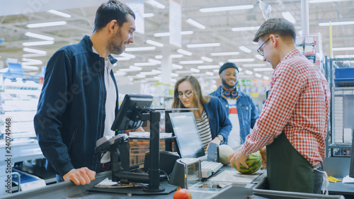 Billede på lærred At the Supermarket: Checkout Counter Professional Cashier Scans Groceries and Food Items