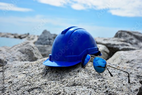 Safety Helmet and the sun glasses on the seascape background
