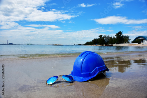 Safety Helmet and the sun glasses on the seascape background
