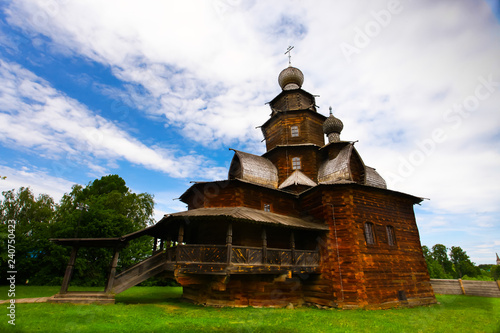 Wooden Orthodox church on green grass © Mikhail Semenov