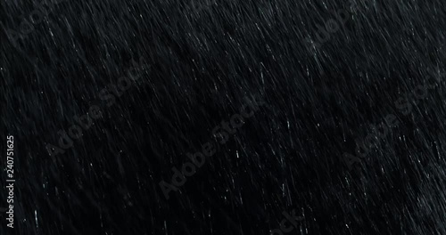 Diagonal heavy rain falling in front of the camera against black screen. Raindrops splashing. Rain closeup vfx insert. Practical seamlessly loopable footage. Heavy rainstorm hitting black surface. photo
