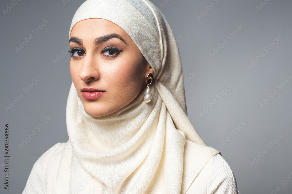 portrait of beautiful young muslim woman looking at camera isolated on grey portrait of beautiful young muslim woman looking at camera isolated on grey