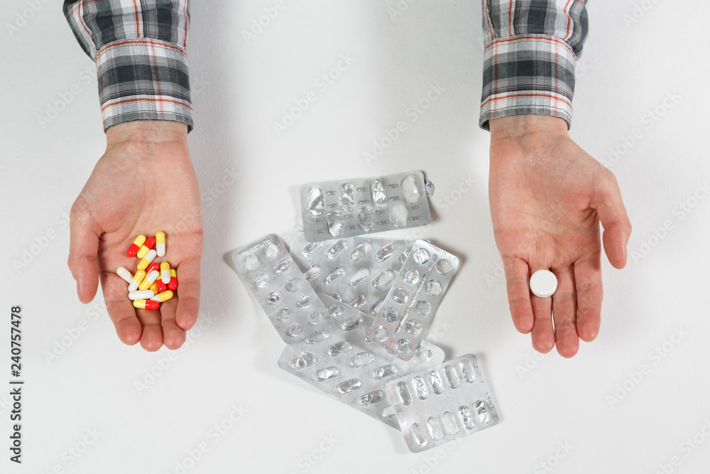 Obraz premium man hand with pill on the background of pills