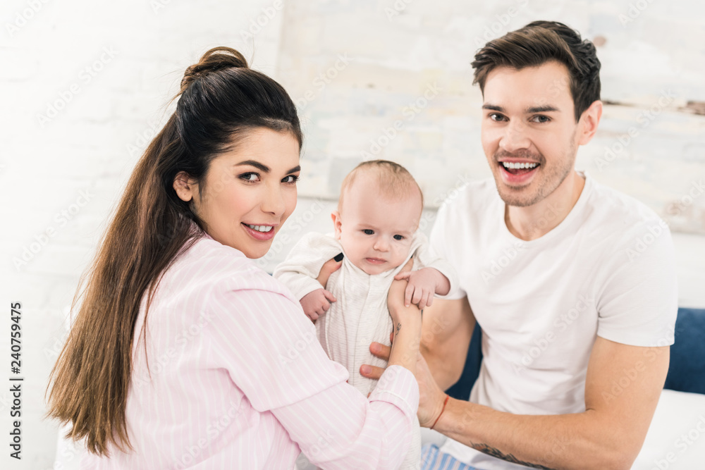 parents and little baby resting on bed together at home parents and little baby resting on bed together at home