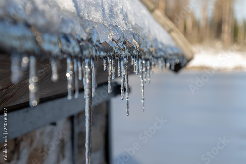 some icicles hanging at the gutter under the roof in winter