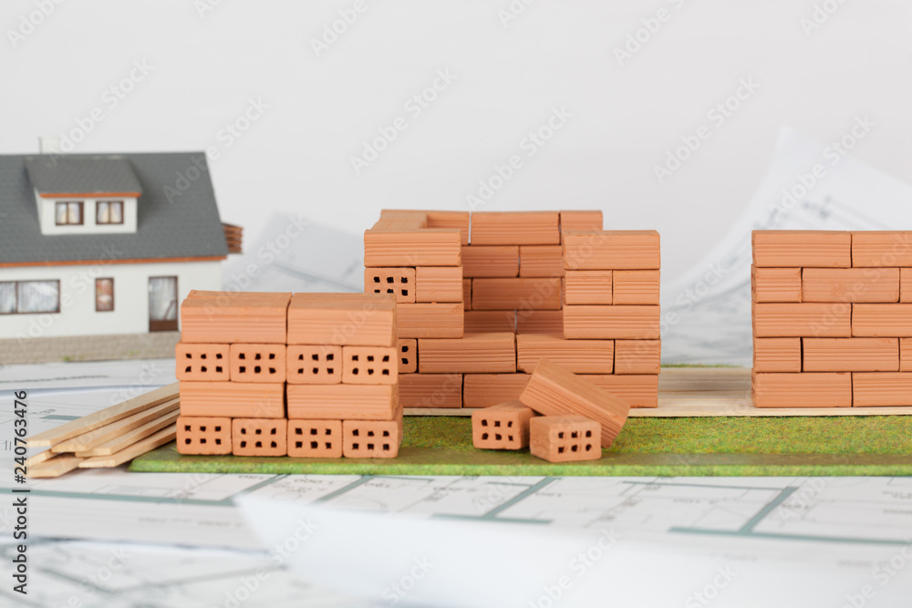 Fototapeta premium Model house construction with brick on blueprint