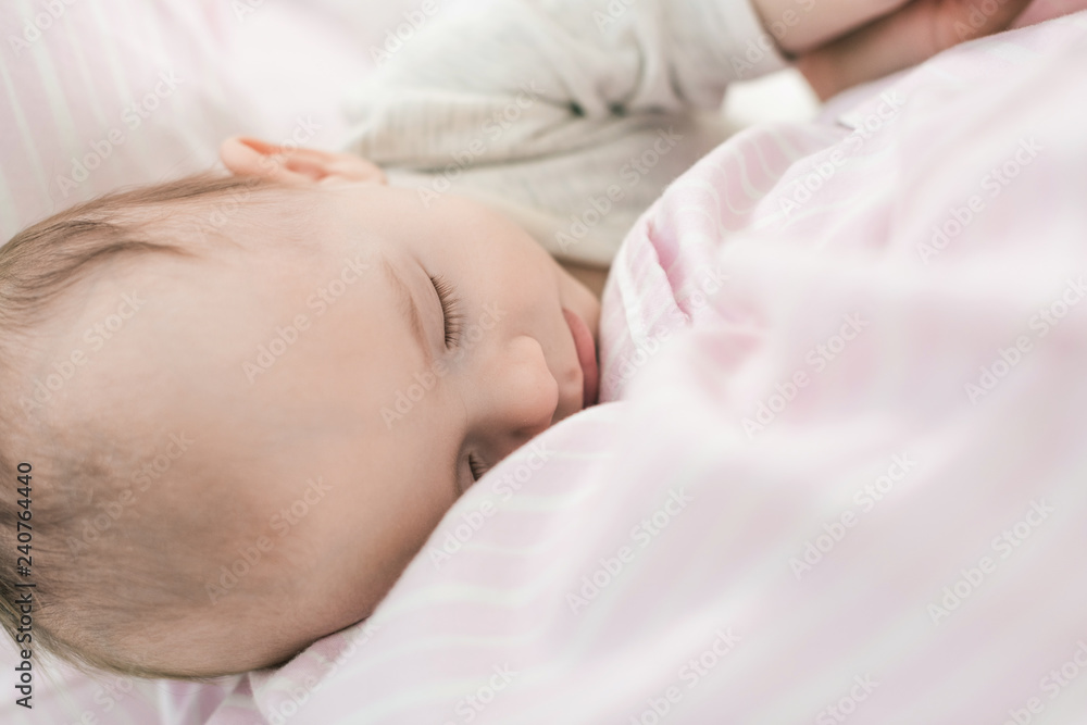 partial view of cute baby sleeping on mothers hands partial view of cute baby sleeping on mothers hands