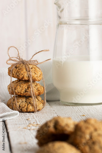 Oatmeal cookies with milk on tray on rustic wooden table