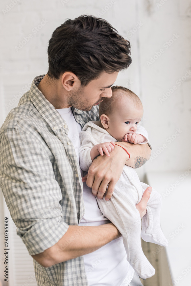 side view of young father and little baby at home