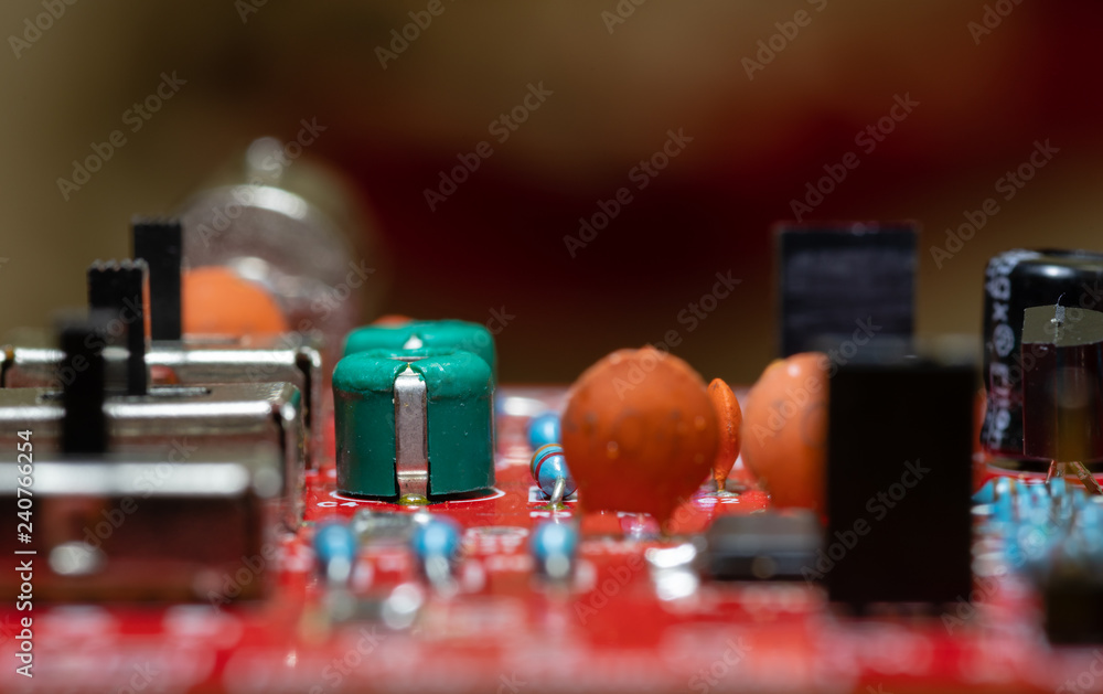 Close up (Macro) of Printed Circuit Board PCB embedded components (inductors, resistors, capacitors, diodes, microchips, transistor) with short depth of view Close up (Macro) of Printed Circuit Board PCB embedded components (inductors, resistors, capacitors, diodes, microchips, transistor) with short depth of view