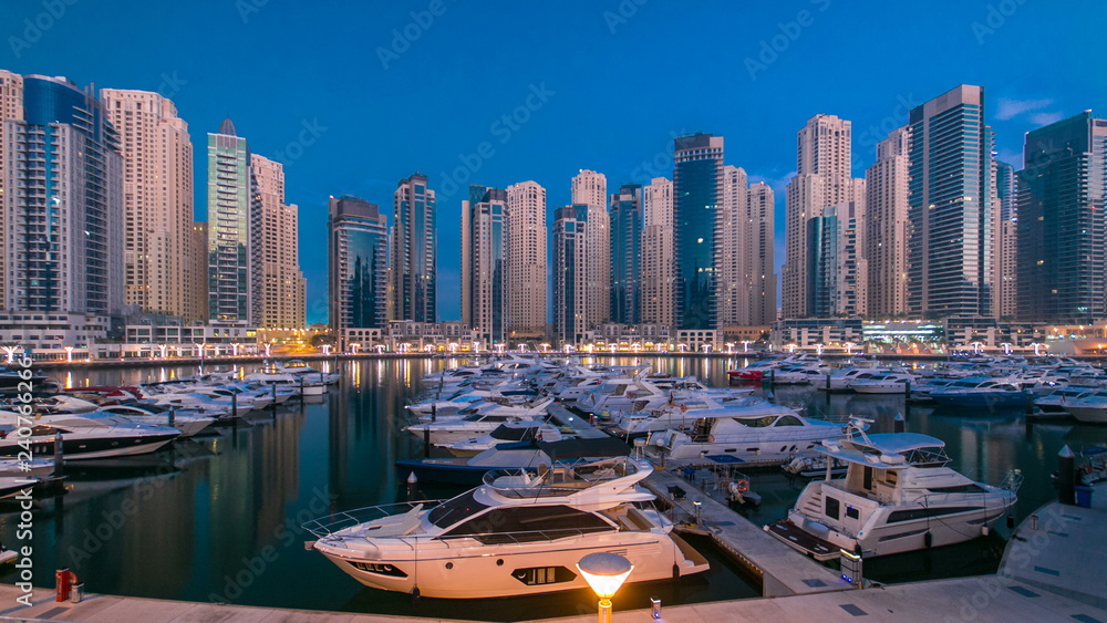 Obraz premium Dubai Marina at Blue hour night to day timelapse with yachts