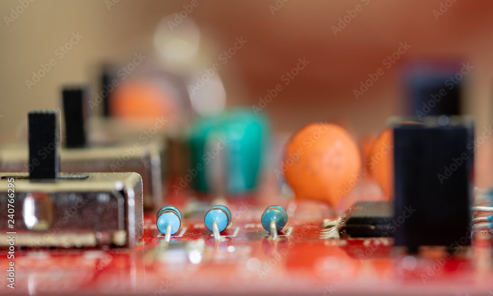 Close up (Macro) of Printed Circuit Board PCB embedded components (inductors, resistors, capacitors, diodes, microchips, transistor) with short depth of view Close up (Macro) of Printed Circuit Board PCB embedded components (inductors, resistors, capacitors, diodes, microchips, transistor) with short depth of view
