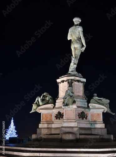 David Statue at Piazzale Michelangelo, with illuminated Christmas tree on background. Florence, Italy