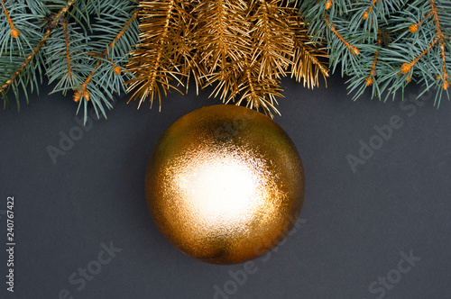 Creative decoration pattern with green and golden Christmas tree branches and big bauble. Concept