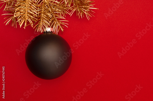 Creative pattern with golden Christmas tree branches and big black bauble. Concept