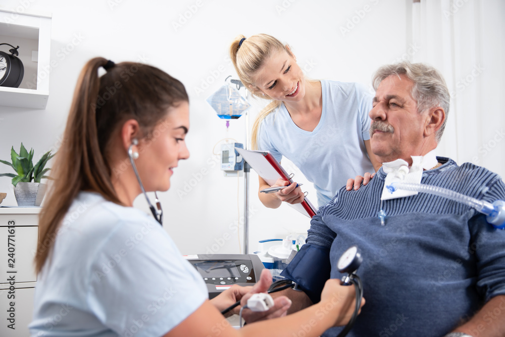 zwei Krankenschwestern pflegen einen intensiv wachkoma Patienten im Krankenhaus oder Pflegeheim auf zwei Krankenschwestern pflegen einen intensiv wachkoma Patienten im Krankenhaus oder Pflegeheim auf