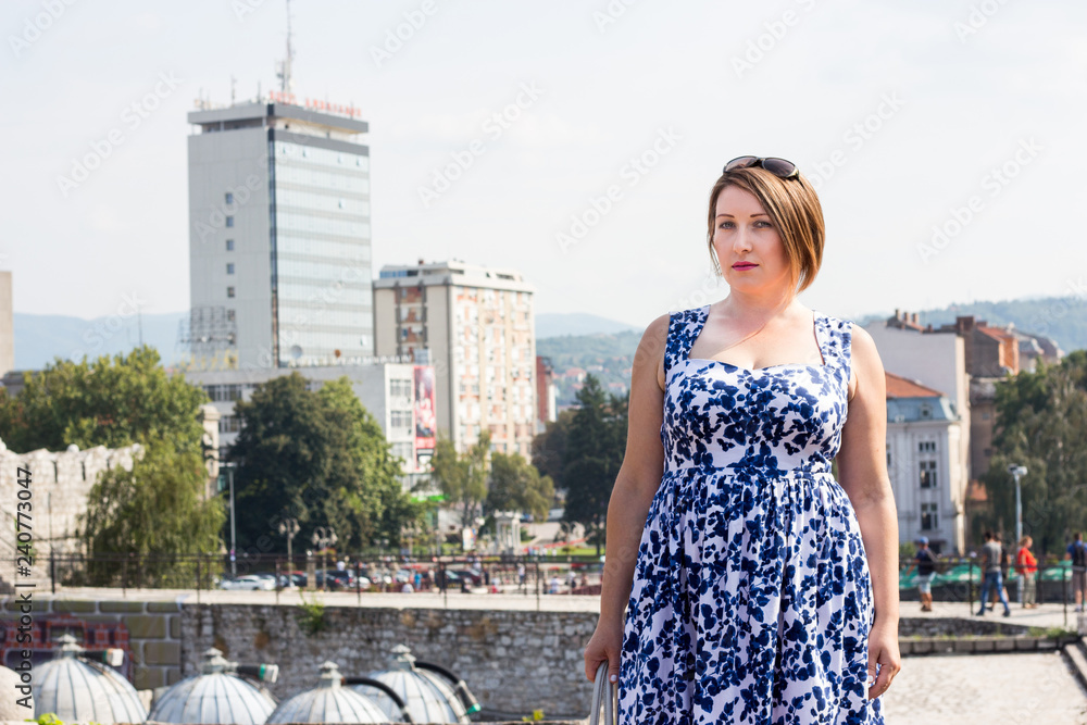 Beautiful Girl in a Blue Dress Posing With Panoramic View of the City Behind Her