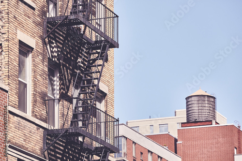 Old building fire escape, retro color toning applied, New York City, USA.
