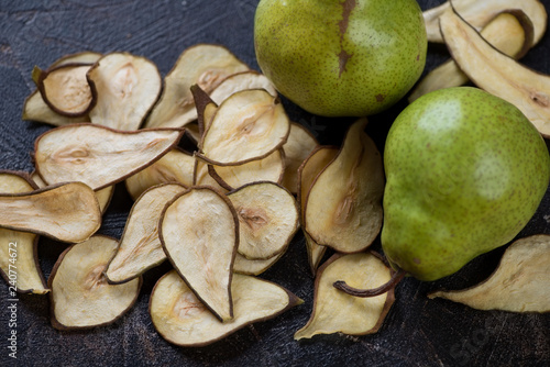 Closeup of crispy fruit chips made of pear and ripe pears, studio shot