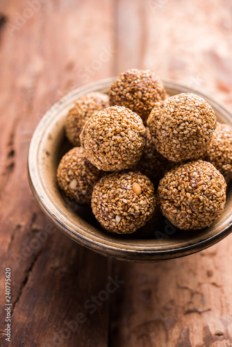 Tilgul Laddu or Til Gul balls for makar sankranti, it's a healthy food made using sesame, crushed peanuts and jaggery. served in a bowl. selective focus showing details.