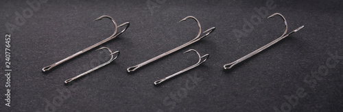double hooks for fishing of various sizes on a black background close-up