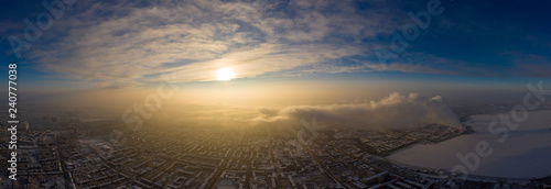 winter sunset over industrial city with lake