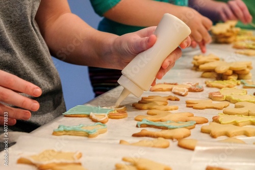 Children are decorating Christmas cookies in preparation for Santa's arrival.