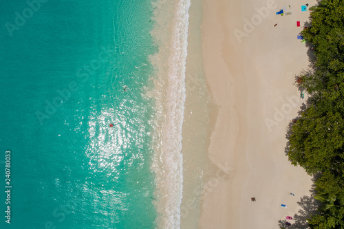 Aerial view of sandy beach with tourists swimming in beautiful clear sea water