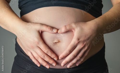 Unrecognizable pregnant woman caressing her belly