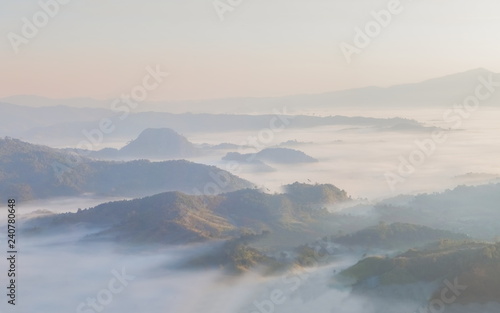 Mountain view morning of the hill around with the ocean of mist with blue sky background, sunrise at Tham Sakoen View Point attraction on route 1148, Tham Sakoen National Park, Nan, Thailand.