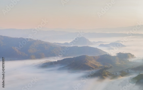 Mountain view morning of the hill around with the ocean of mist with blue sky background, sunrise at Tham Sakoen View Point attraction on route 1148, Tham Sakoen National Park, Nan Province, Thailand.