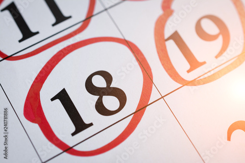 Photos Red circle marked with pen on a calendar sheet eighteenth of the calendar date