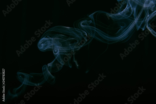smoke wriggles around in different patterns on a black background.